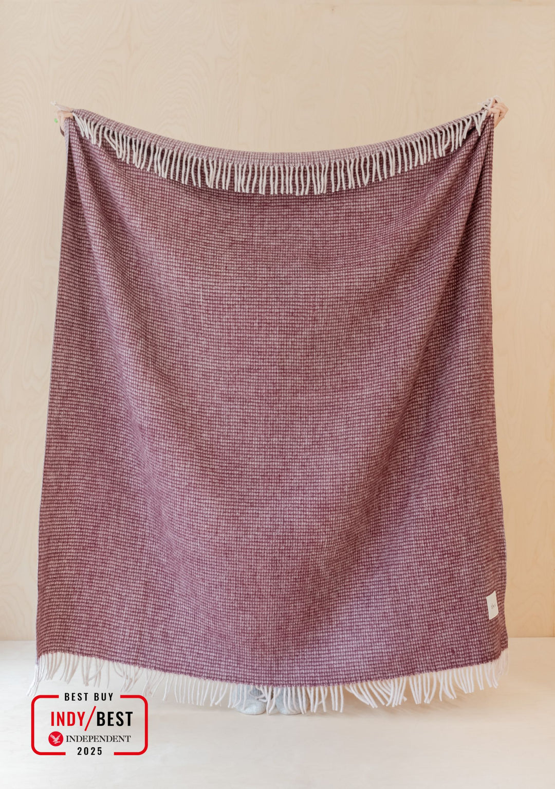 TBCo Berry Waffle Recycled Wool Blanket with fringed edges displayed hanging, showing textured waffle pattern in deep berry colour