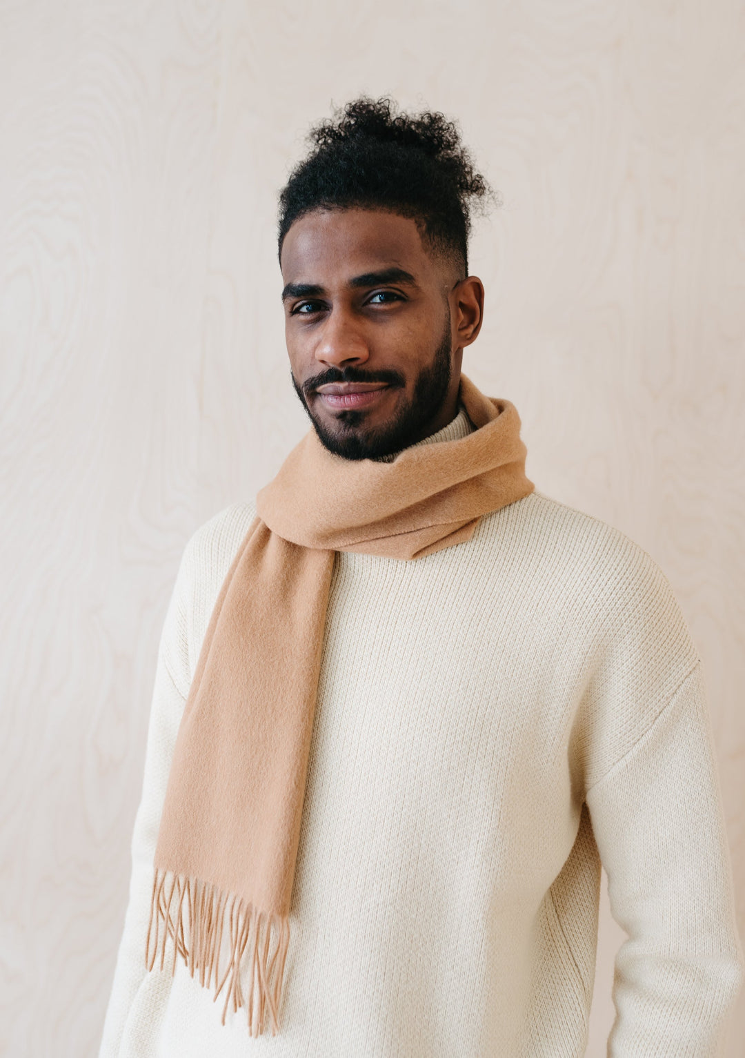 TBCo Men's Cashmere Scarf in Camel draped stylishly over cream knit jumper, showcasing luxurious fringe detail and natural drape