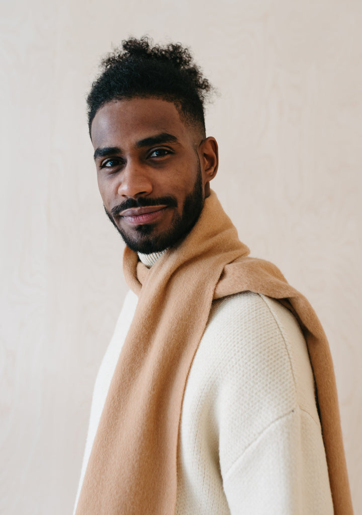 Luxurious TBCo Men's Cashmere Scarf in Camel styled casually with cream jumper showing soft drape and fringed detail