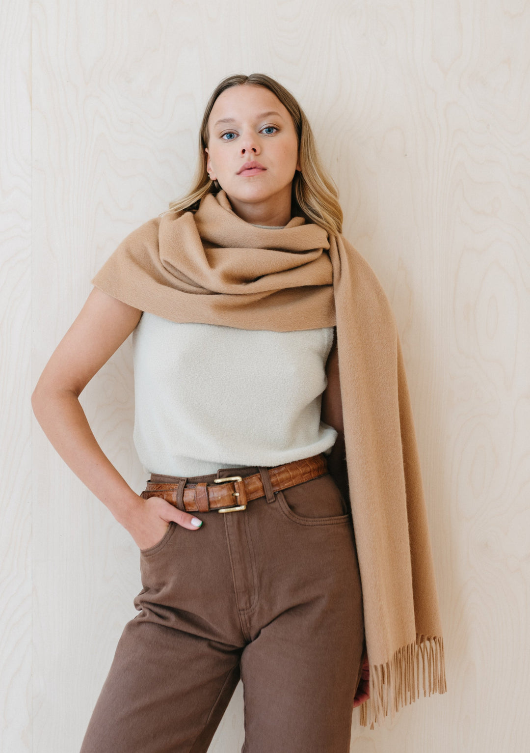 Luxurious TBCo lambswool blanket scarf in camel with fringe detail, styled casually with white top and brown trousers