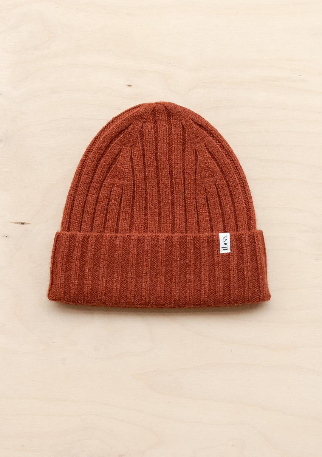 TBCo Cashmere & Merino Beanie in rust colour featuring ribbed texture and folded brim with signature label detail