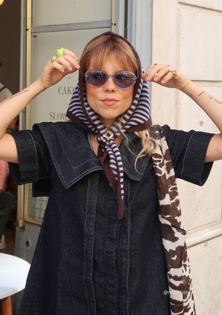 Woman wearing Merino Wool Triangle Scarf in Blue & Brown Stripe tied under chin featuring TBCo embroidered logo