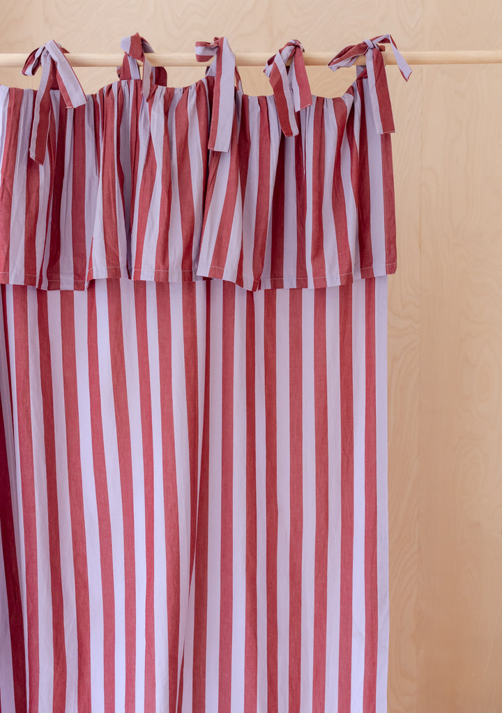 Pair of Cotton Tie-Top Curtains in Lilac Stripe from TBCo hanging with soft lilac and pink stripes on a wooden rail
