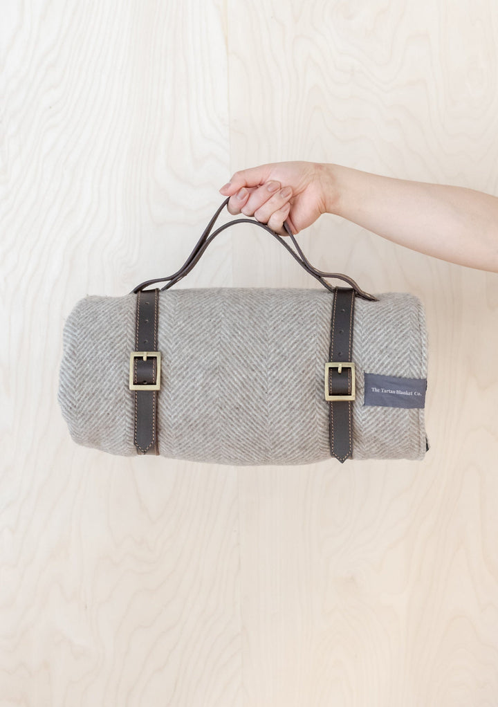 TBCo Picnic Blanket with Leather carrier with sturdy brass buckles, designed for securely carrying rolled-up wool picnic blankets. A timeless and practical accessory for stylish outdoor adventures and easy transport.