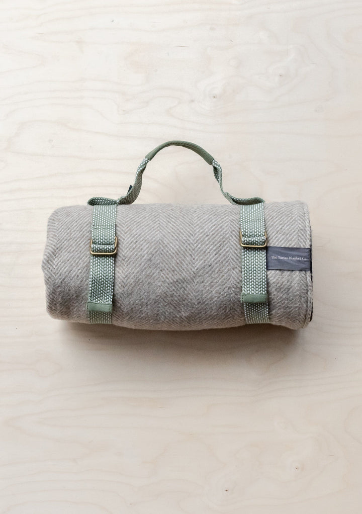 Grey TBCo Recycled Picnic Carrier with sage green straps rolled in portable blanket carrying position