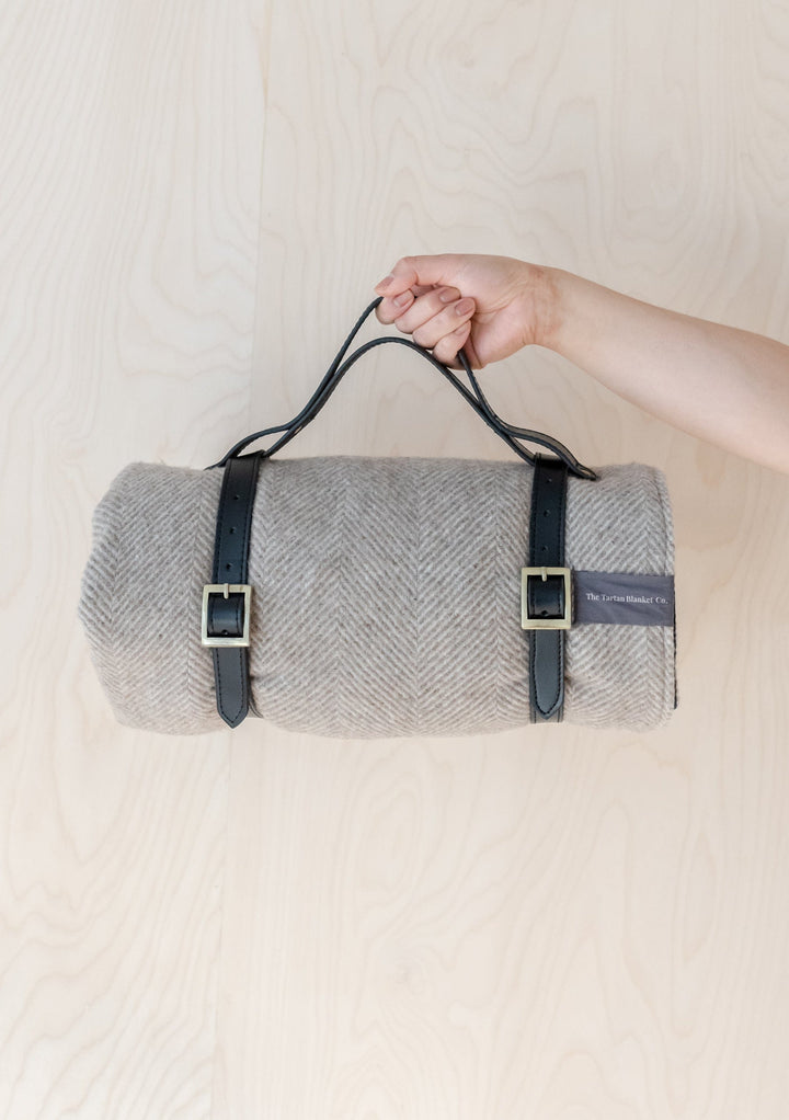TBCo Picnic Blanket with Leather carrier with sturdy brass buckles, designed for securely carrying rolled-up wool picnic blankets. A timeless and practical accessory for stylish outdoor adventures and easy transport.