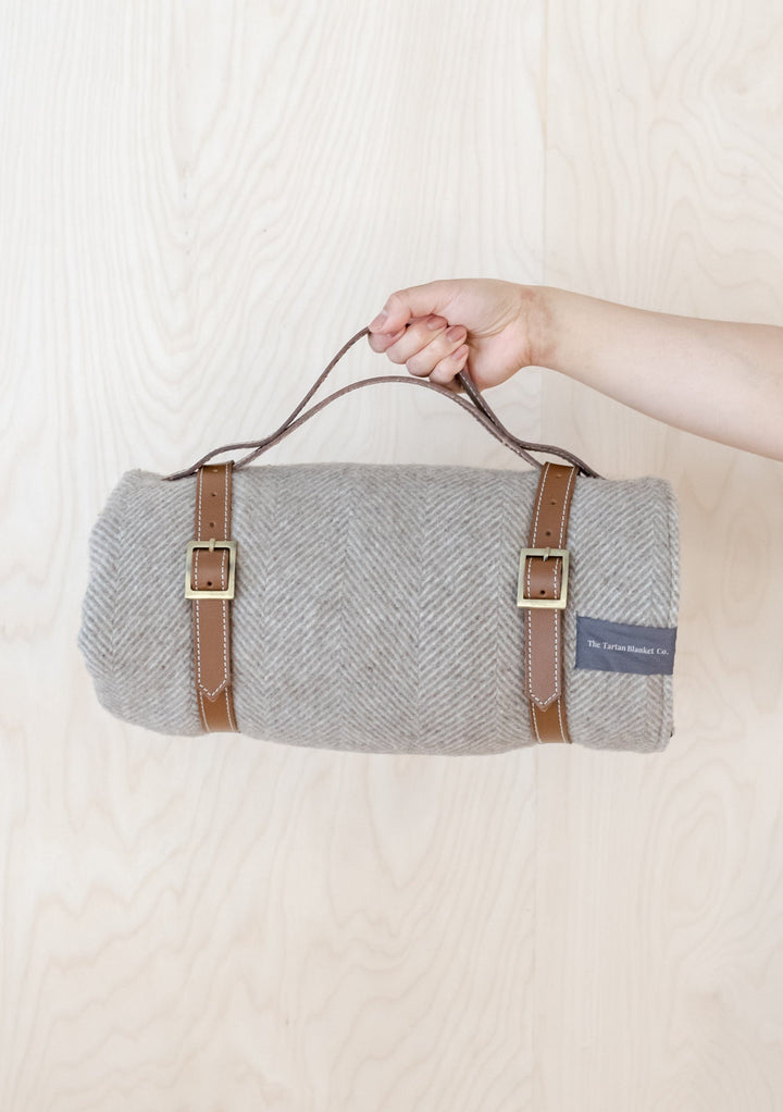 TBCo Picnic Blanket with Leather carrier with sturdy brass buckles, designed for securely carrying rolled-up wool picnic blankets. A timeless and practical accessory for stylish outdoor adventures and easy transport.