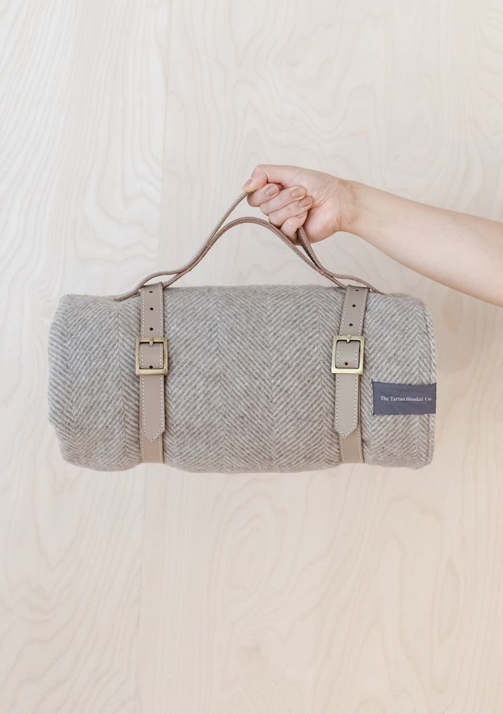 TBCo Picnic Blanket with Leather carrier with sturdy brass buckles, designed for securely carrying rolled-up wool picnic blankets. A timeless and practical accessory for stylish outdoor adventures and easy transport.