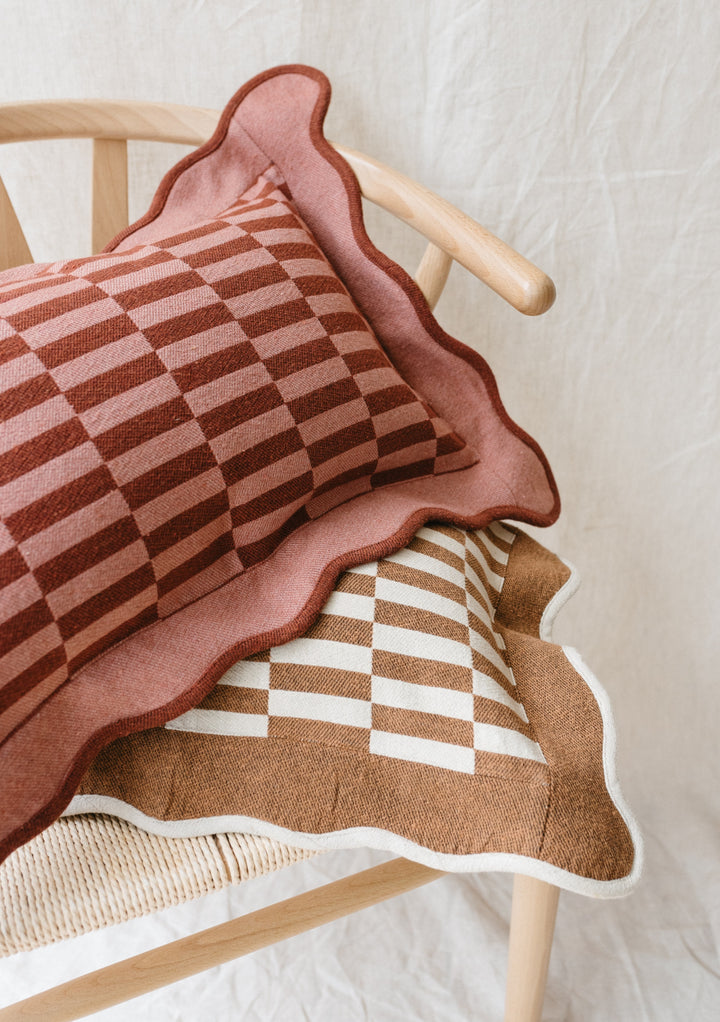 TBCo Cotton Cushion Cover in rose checkerboard pattern with scalloped edges, showcasing geometric design on wooden chair