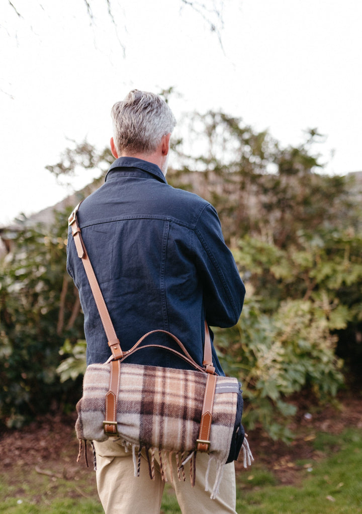 TBCo wool picnic blankets with carrier and should strap arranged in a scenic outdoor setting, showcasing their soft texture and vibrant patterns. Perfect for alfresco dining, relaxing in nature, or stylish outdoor gatherings.
