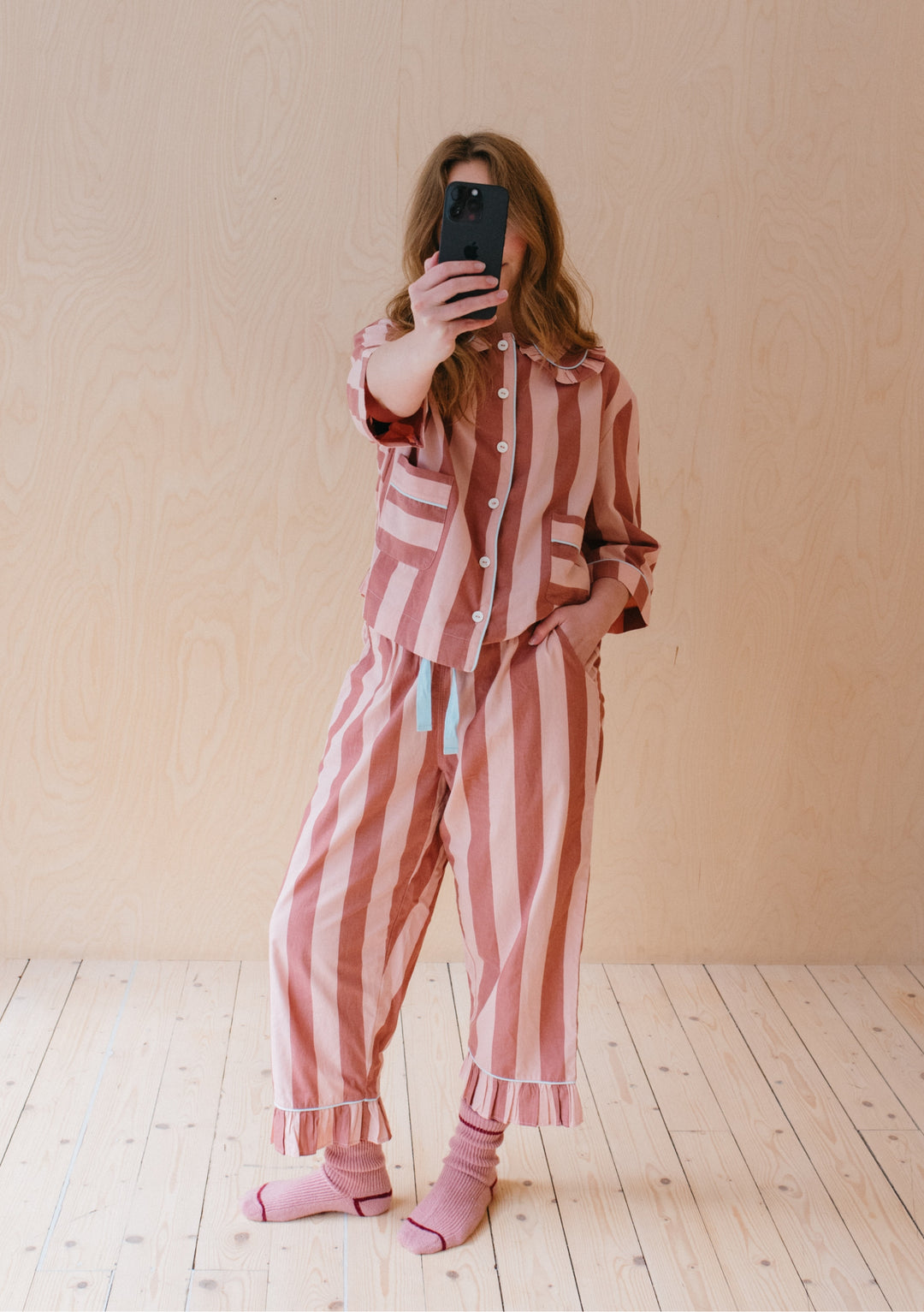 TBCo Cotton Pyjamas in pink and red vertical stripes with ruffled collar and button-front design, shown on wooden floor