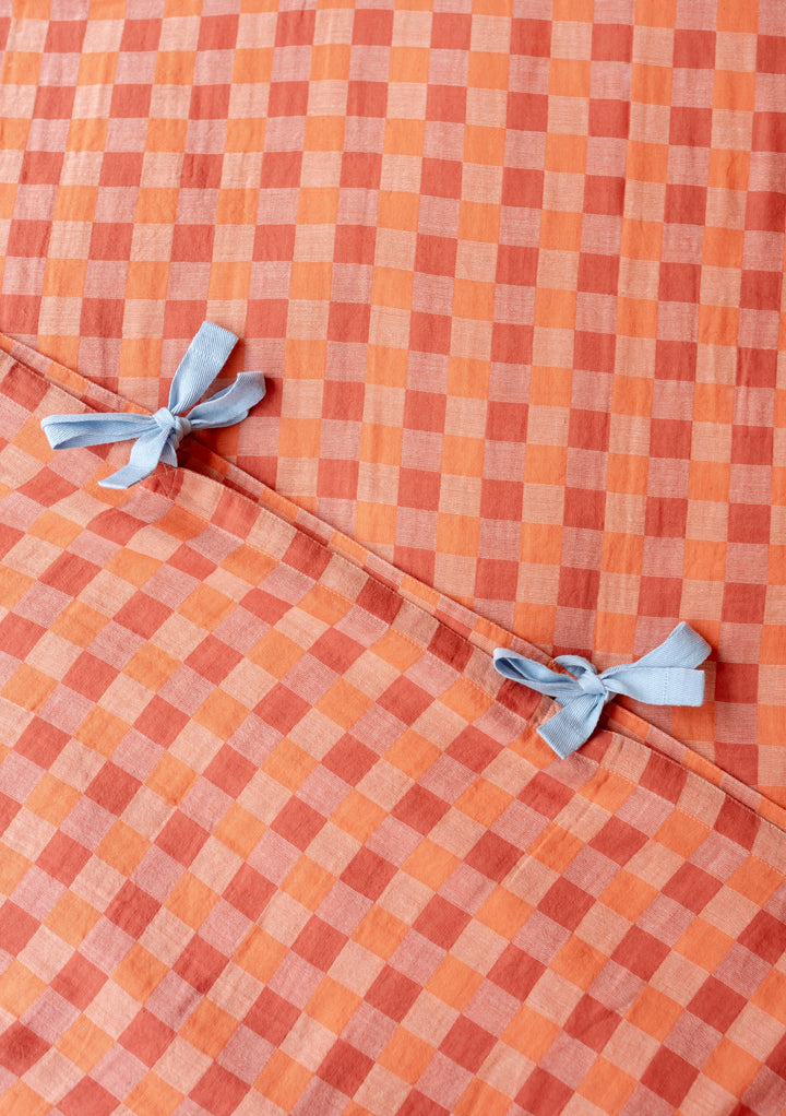 TBCo Cotton Duvet Cover in apricot checkerboard pattern with light blue bow ties, close-up view of textile detail