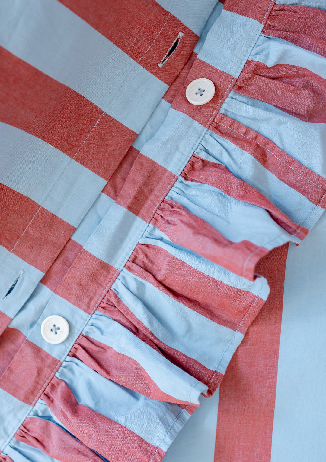 TBCo Cotton Duvet Cover with blue and red wide stripes, white buttons and ruffled edges, shown in close-up detail view
