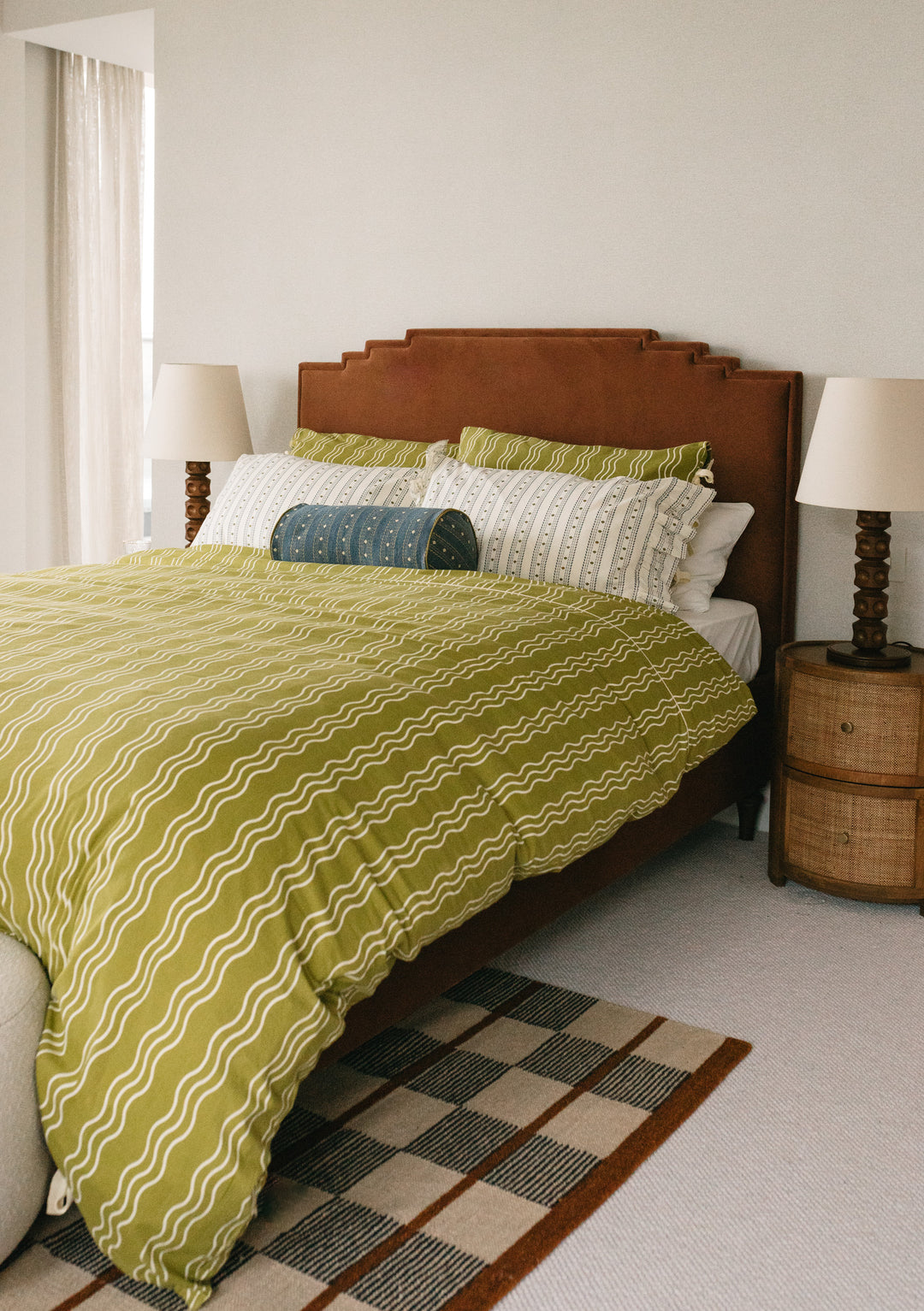 TBCo Cotton Duvet Cover in Olive Wave displayed on bed with wooden headboard, featuring wavy pattern and coordinating pillowcases