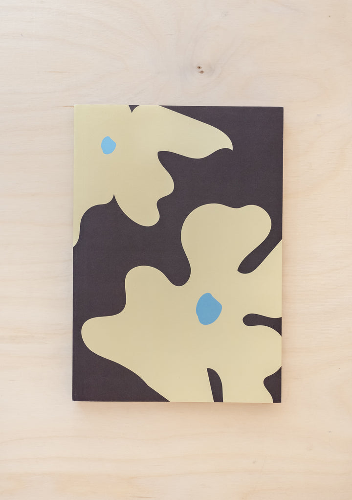 TBCo Flora Notebook featuring abstract cream flowers with blue accents on charcoal grey background, stylish A5 paper cover design