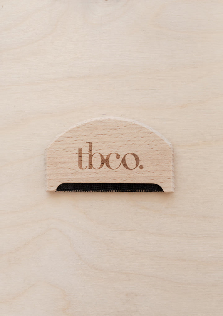 TBCo wooden wool comb made from natural beechwood featuring brand logo, designed for gentle wool care and depilling