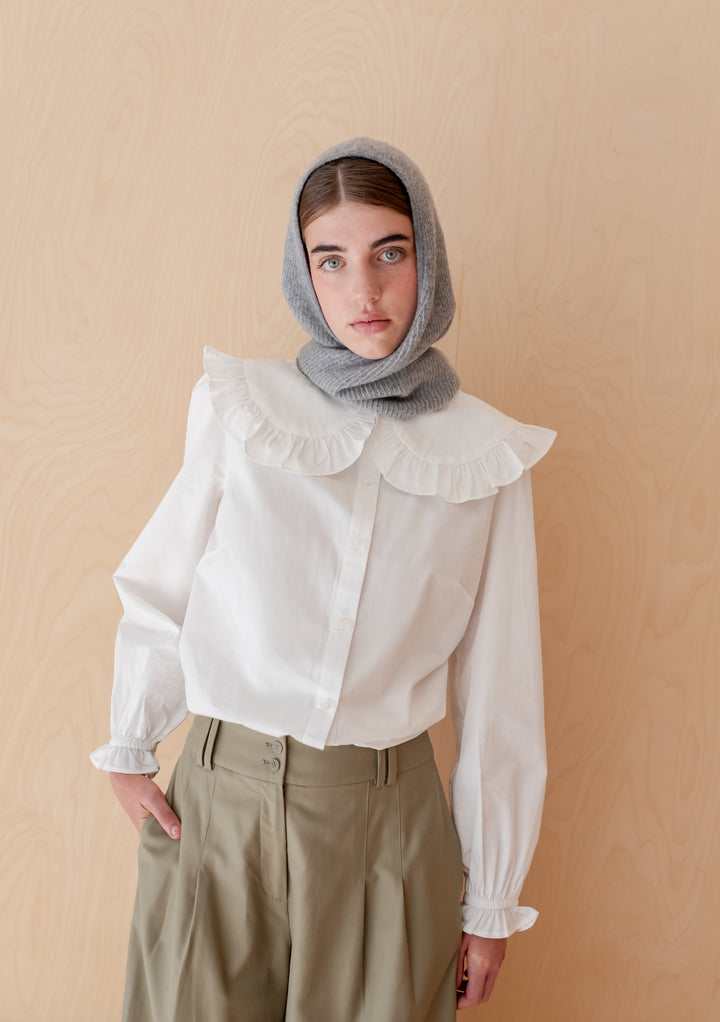 Model wearing TBCo Merino Hood in Grey Two-Tone styled with white blouse and khaki trousers against neutral background