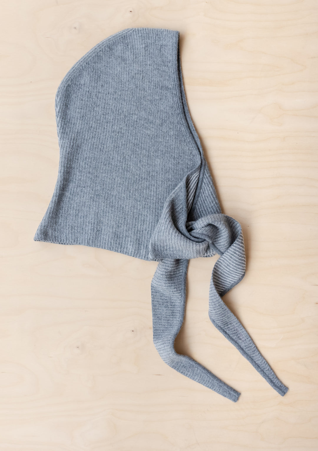 Merino Hood in Grey Two-Tone by TBCo laid flat showing soft ribbed merino wool with long ties for styling versatility