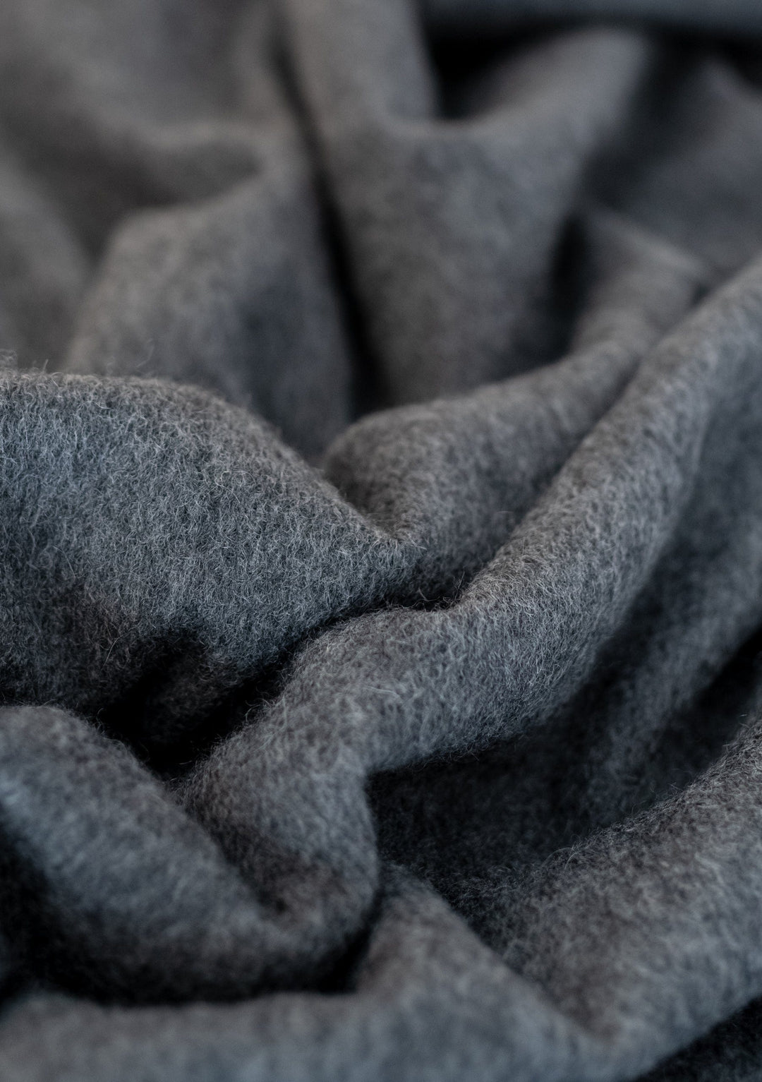 Close-up texture detail of TBCo Men's Cashmere Scarf in Charcoal Melange showing soft, luxurious fabric folds