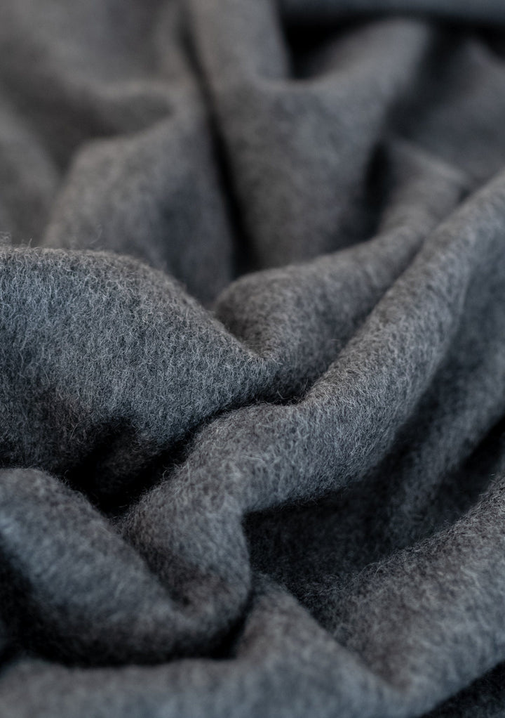 Close-up texture detail of TBCo Men's Cashmere Scarf in Charcoal Melange showing soft, luxurious fabric folds