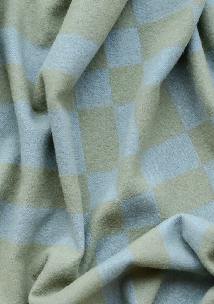 TBCo Lambswool Blanket in Blue Pillar Check featuring soft, textured wool in sage green and powder blue check pattern