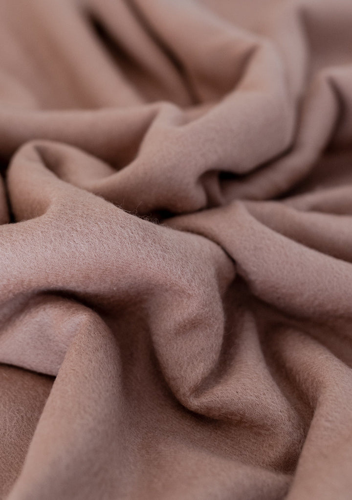 Close-up texture detail of TBCo Lambswool Oversized Scarf in Blush showing soft, draped wool fabric with gentle folds