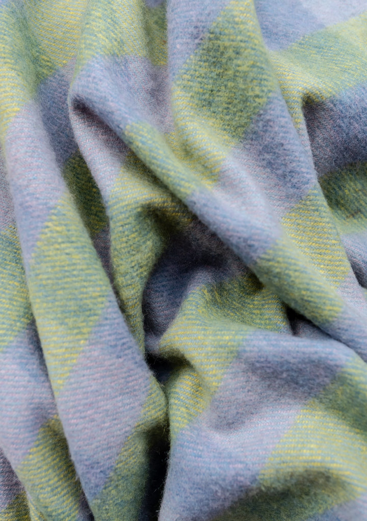 Close-up texture of TBCo Recycled Wool Blanket in green and blue gingham pattern showing soft woven wool fabric with gentle folds