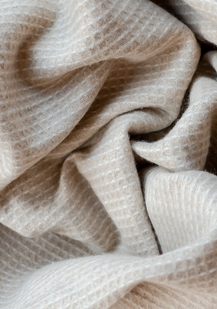 Close-up texture detail of TBCo Recycled Wool Waffle Blanket in Camel showing soft, woven pattern and natural fibres