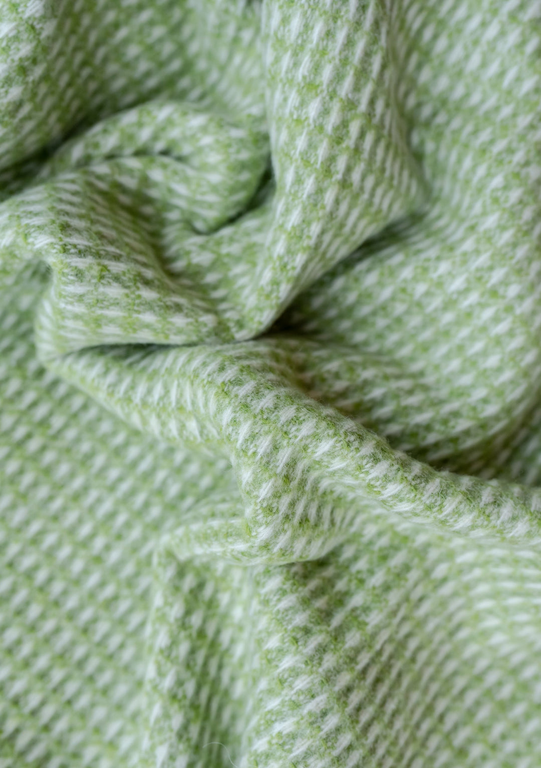 Close-up texture detail of TBCo Recycled Wool Blanket in Green Waffle showing soft, textured weave pattern in lime green shade