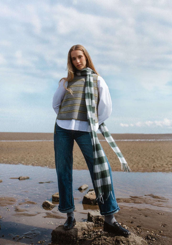 Model wearing TBCo Lambswool Skinny Scarf in Forest Gingham with casual outfit by the beach on a cool day