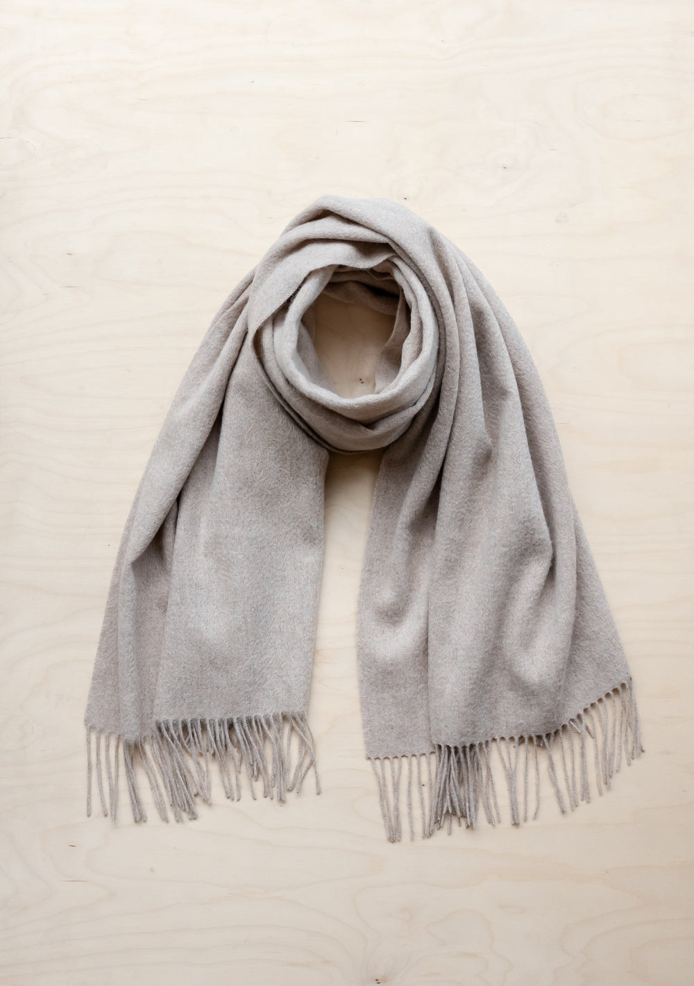 TBCo Lambswool Blanket Scarf in Oatmeal Melange with fringed edges, elegantly draped to showcase soft texture and natural colour