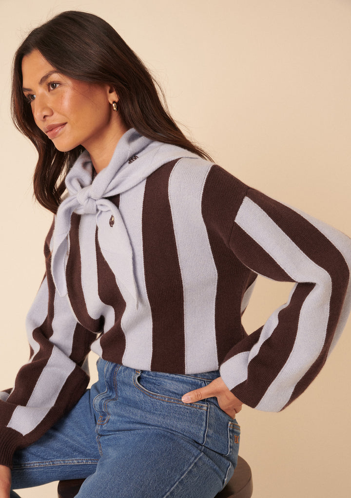 Woman wearing NC x TBCo Blue Floral Wool Triangle Scarf tied over striped jumper and blue jeans in a studio setting