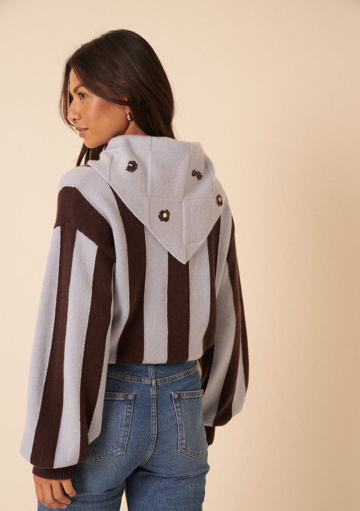 Woman wearing a striped wool jumper with floral embroidered hood from TBCo, styled alongside NC x TBCo Blue Floral Wool Triangle Scarf
