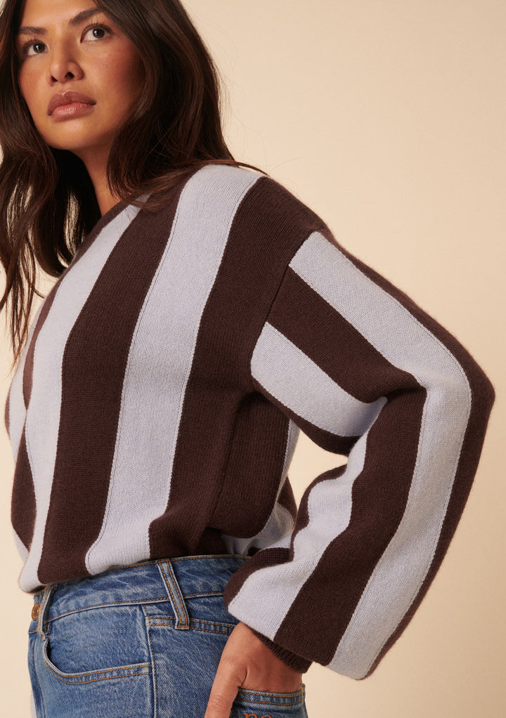 Woman wearing the NC x TBCo Blue Stripe Relaxed Wool Jumper with wide sleeves and blue jeans, standing against a neutral background—an essential knitwear capsule piece.