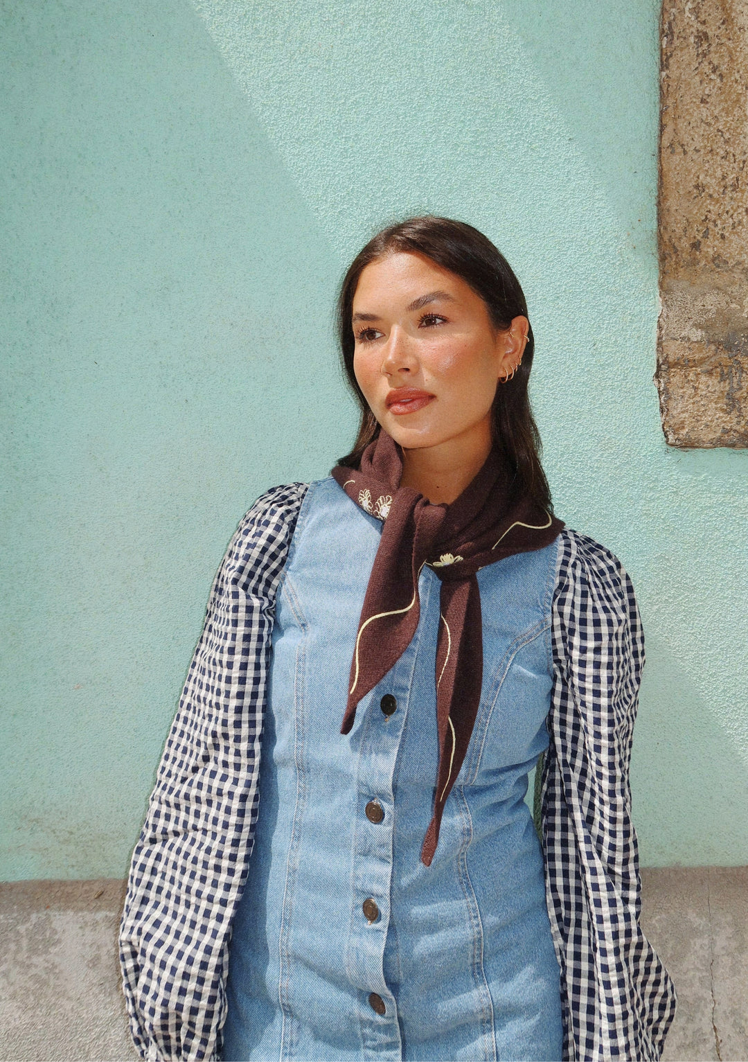 Model wearing the NC x TBCo Latte Floral Wool Triangle Scarf with floral embroidery by TBCo in soft merino wool