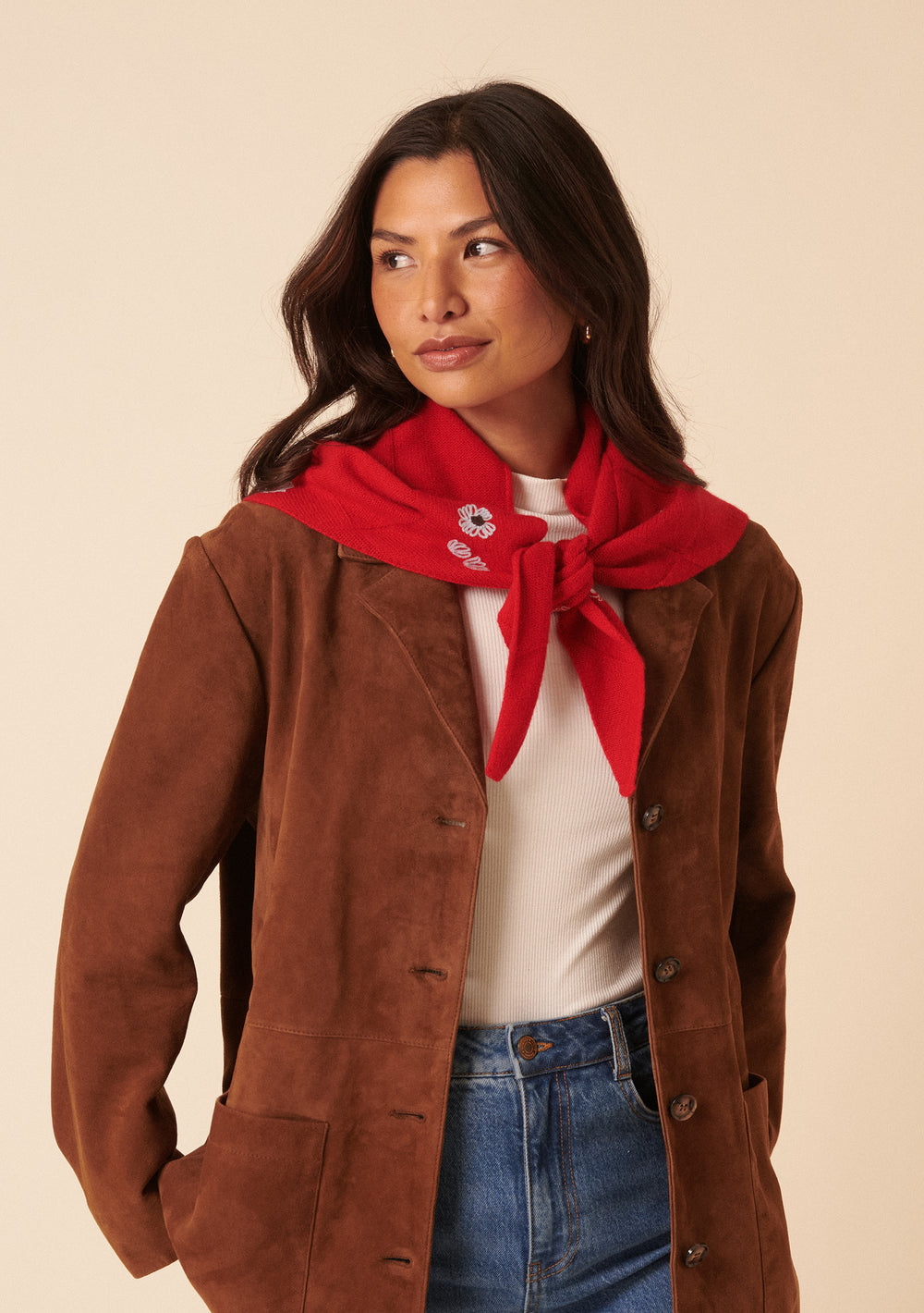 Woman wearing a brown jacket and the NC x TBCo Red Floral Wool Triangle Scarf with blue floral embroidery tied around her neck