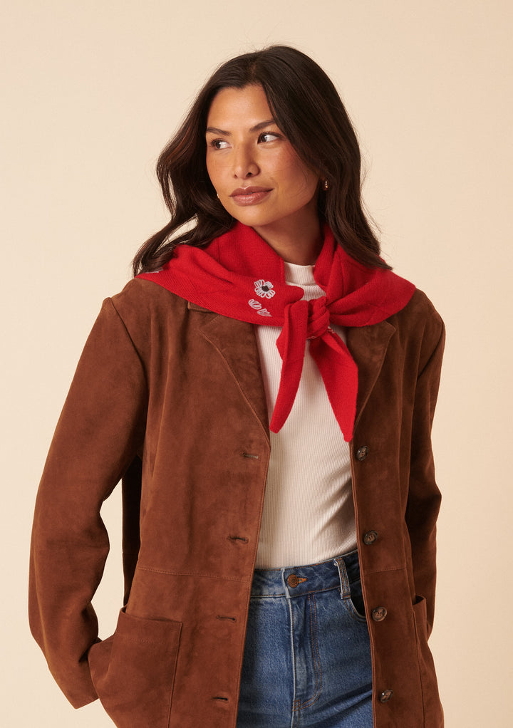 Woman wearing a brown jacket and the NC x TBCo Red Floral Wool Triangle Scarf with blue floral embroidery tied around her neck