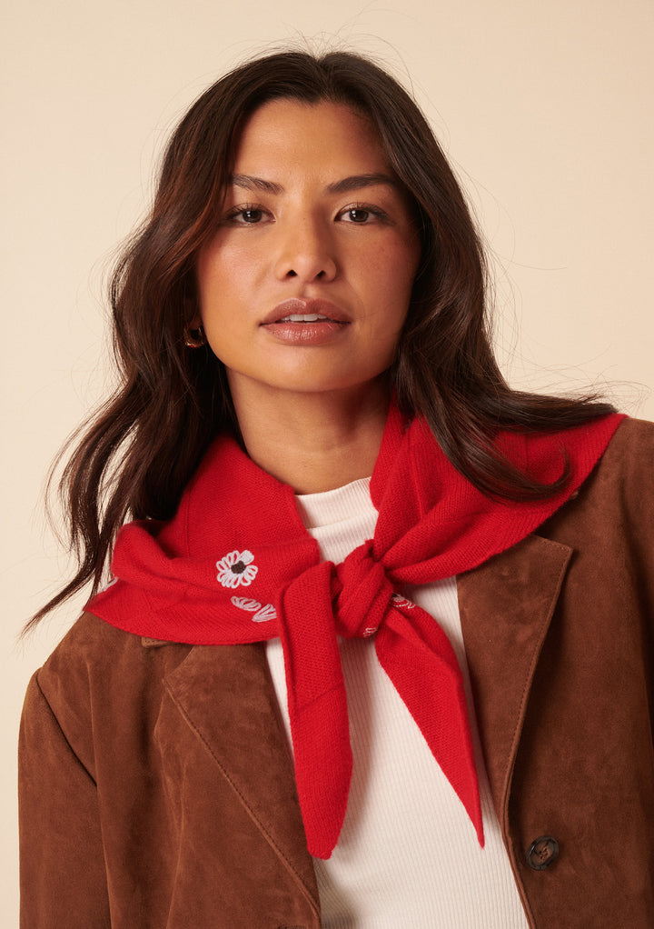 Woman wearing TBCo NC x TBCo Red Floral Wool Triangle Scarf in red merino wool with blue embroidery tied stylishly.