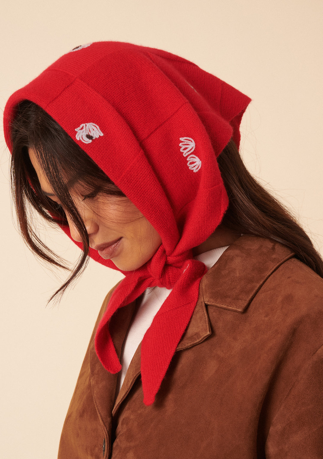 Woman wearing the NC x TBCo Red Floral Wool Triangle Scarf tied under the chin with floral embroidery detail
