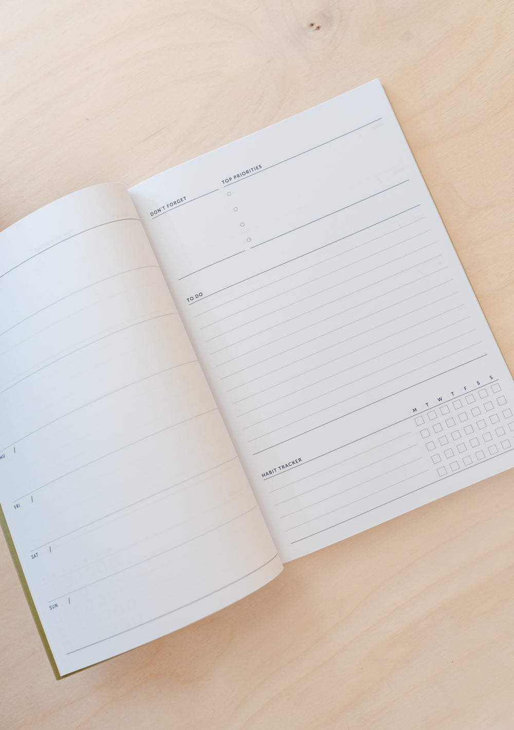 TBCo Stripe Notebook open to show undated planner pages with lined sections and minimalist daily schedule layout