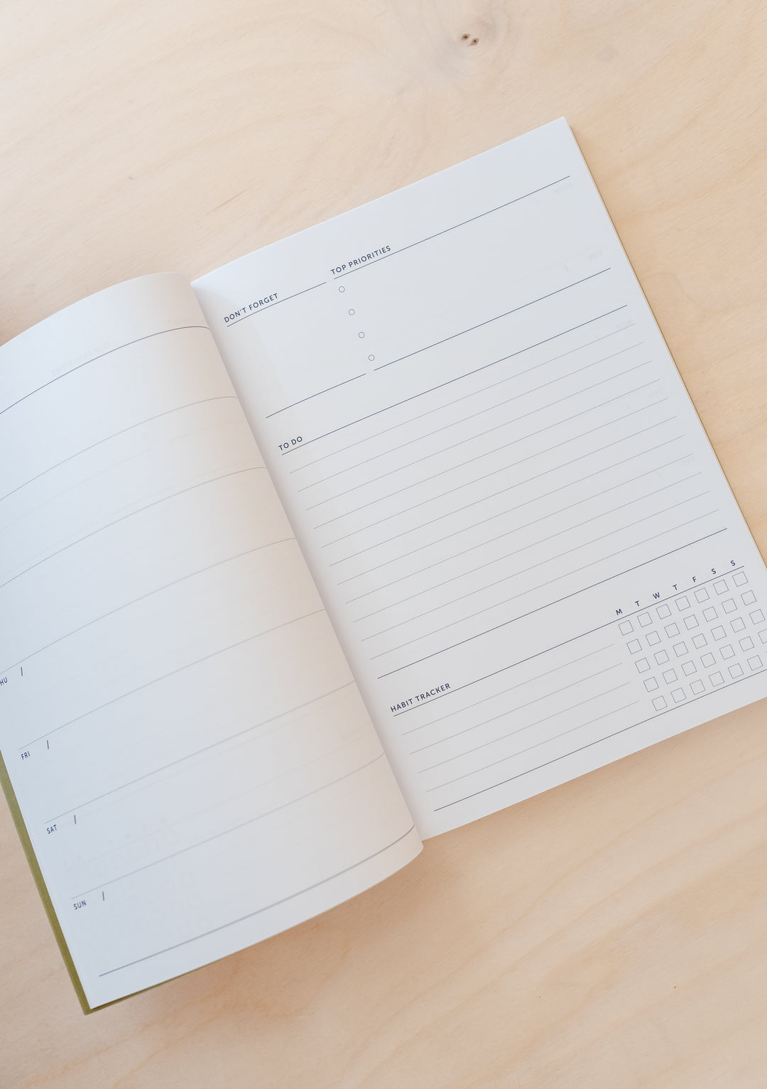 TBCo Stripe Notebook open to show undated planner pages with lined sections and minimalist daily schedule layout