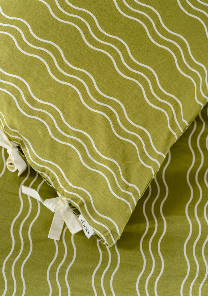 TBCo Cotton Pillowcases in Olive Wave pattern featuring cream wavy stripes and elegant side tie closures on green background
