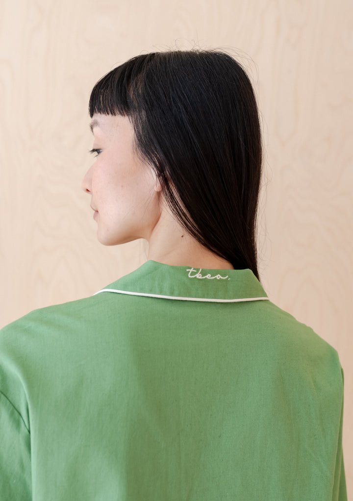 Side view of TBCo Cotton & Linen Pyjamas in green, showcasing embroidered collar detail and relaxed fit on shoulders