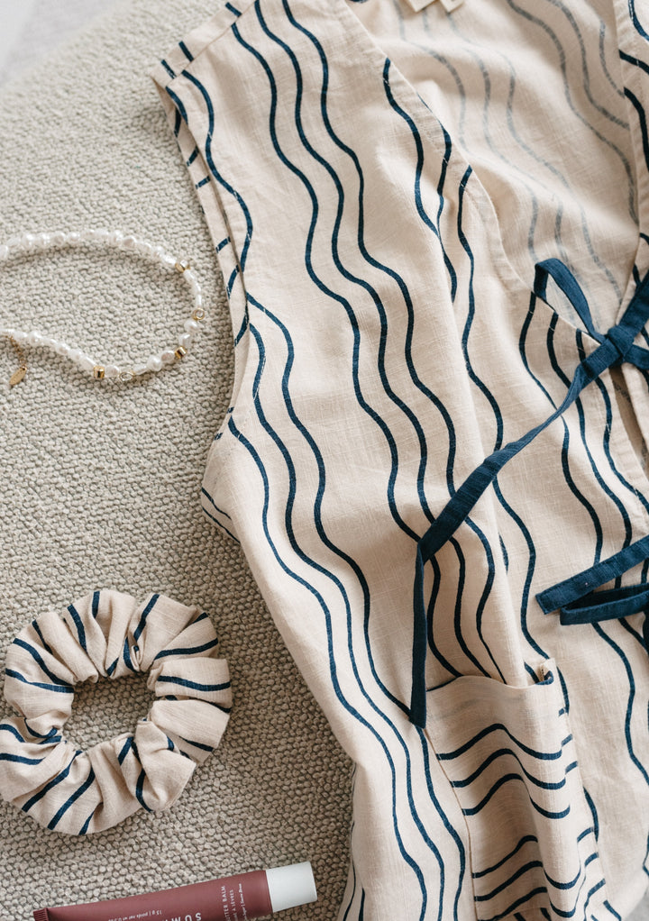 TBCo Cotton Tie Set in Blue Wave features cream fabric with navy wavy stripes and matching scrunchie on textured grey background