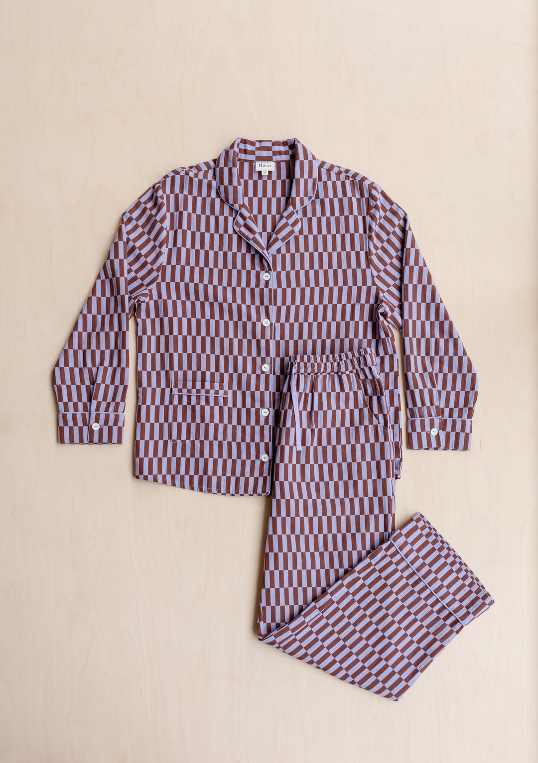 TBCo Cotton Pyjamas in lilac and burgundy checkerboard pattern, featuring collared shirt and matching trousers on beige background