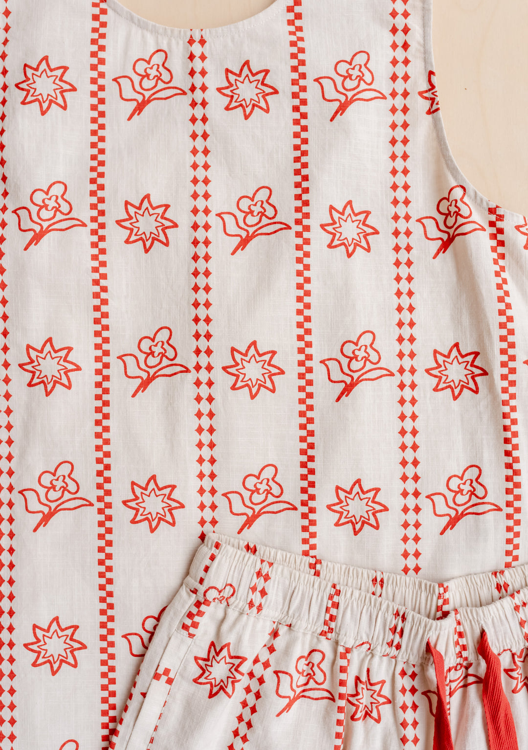 TBCo Cotton Short Set in Flora Sun featuring white fabric with red geometric floral print and cross-back design