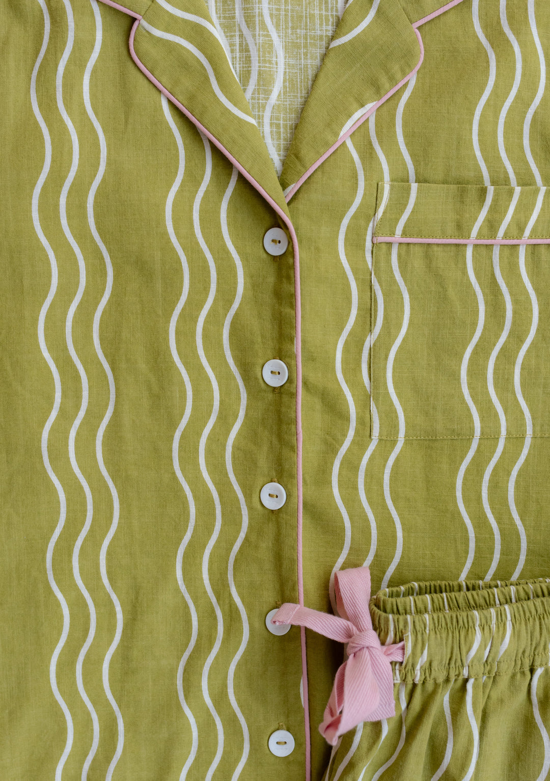 TBCo Cotton Pyjamas in Olive Wave featuring wavy pattern, pink trim and recycled buttons, with collared neckline and elastic waist