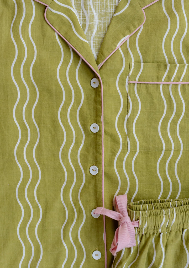 TBCo Cotton Pyjamas in Olive Wave featuring wavy pattern, pink trim and recycled buttons, with collared neckline and elastic waist