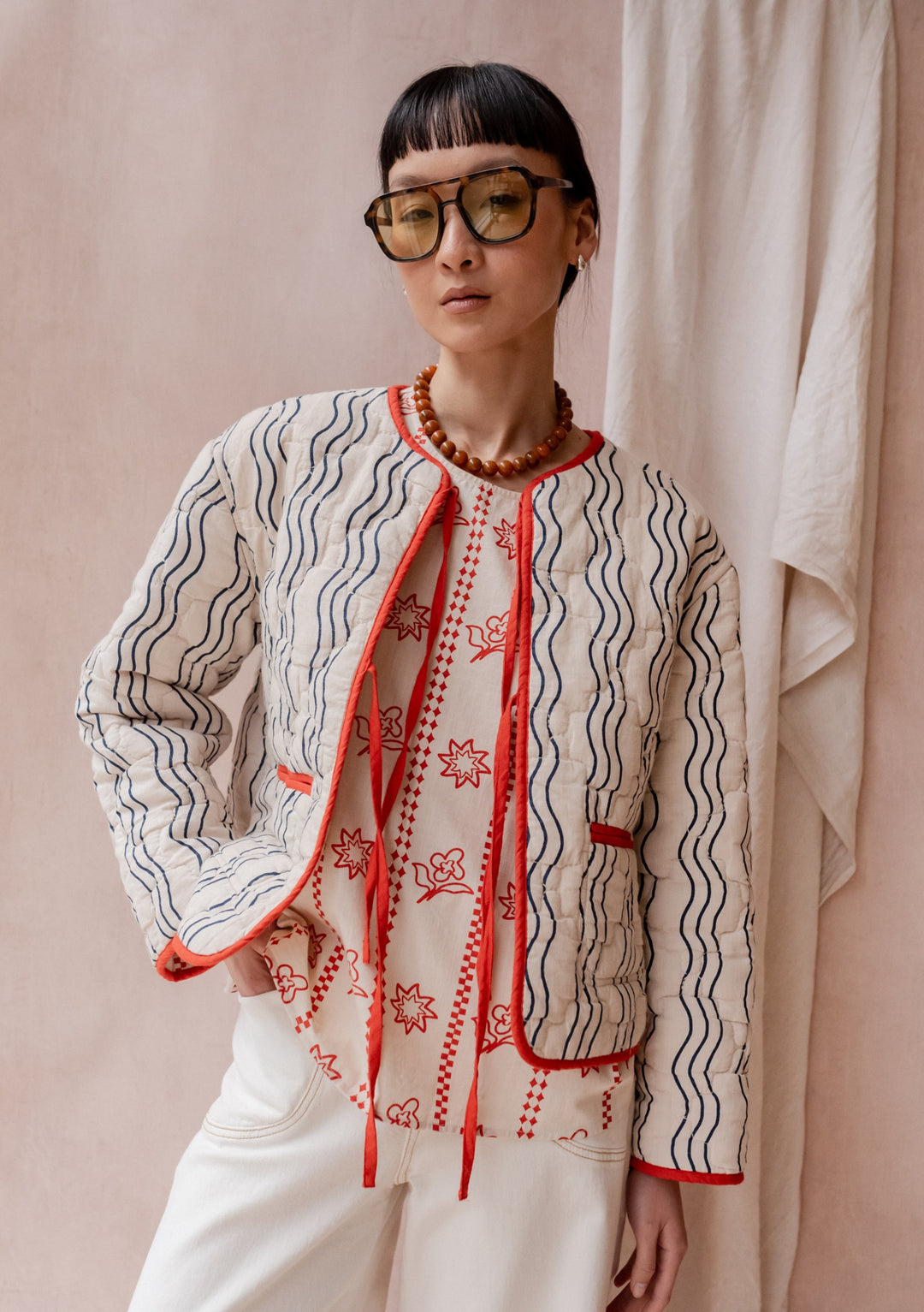 TBCo Quilted Cotton Jacket in Reversible Flora Wave shown with navy wave pattern exterior and orange trim detailing