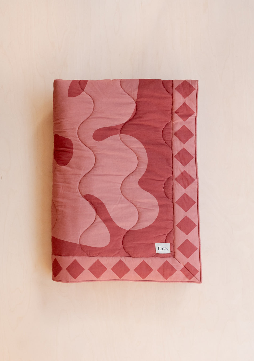TBCo Quilted Cotton Throw in Flora featuring pink and wine organic pattern with diamond border, cotton and recycled filling